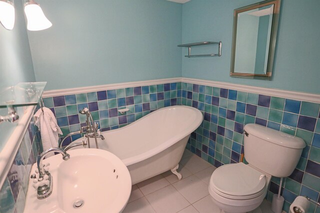 bathroom featuring sink, tile patterned flooring, tile walls, and toilet