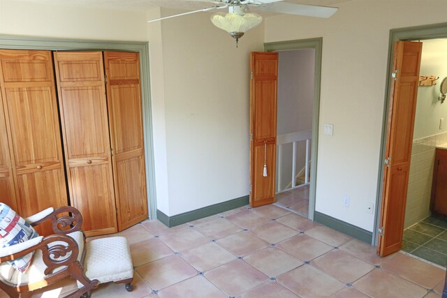 unfurnished bedroom featuring ceiling fan, light tile patterned flooring, and a closet