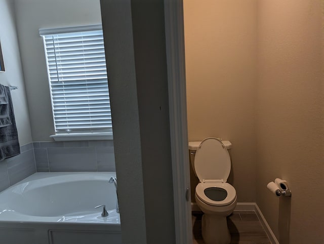 bathroom with a washtub and toilet