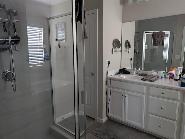 bathroom with hardwood / wood-style flooring, vanity, and an enclosed shower