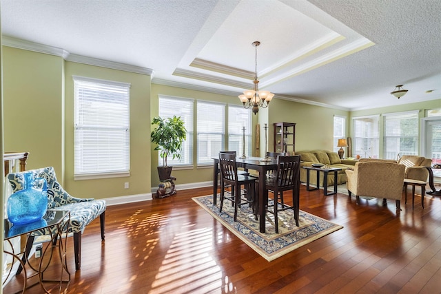 dining space with dark hardwood / wood-style floors, crown molding, a textured ceiling, and a chandelier