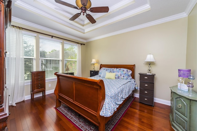 bedroom with ornamental molding, a raised ceiling, ceiling fan, and dark wood-type flooring