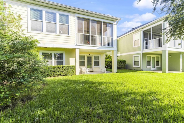 rear view of house with a patio and a lawn