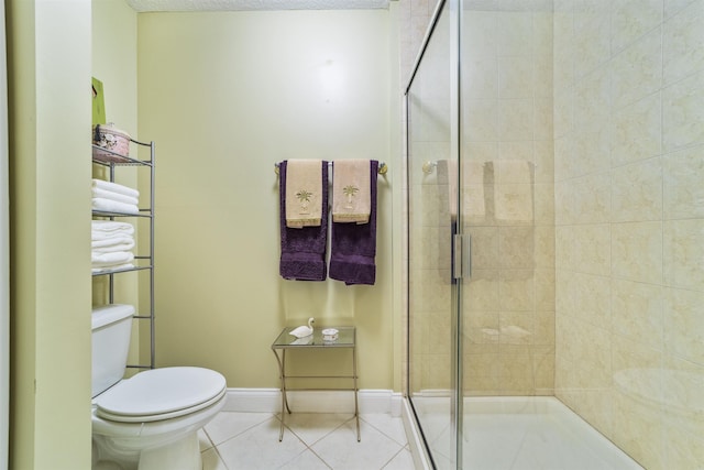 bathroom with tile patterned flooring, toilet, and walk in shower