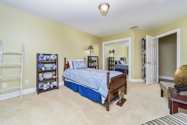 bedroom with light carpet, a textured ceiling, and a closet