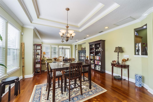 dining room with an inviting chandelier, crown molding, and dark wood-type flooring