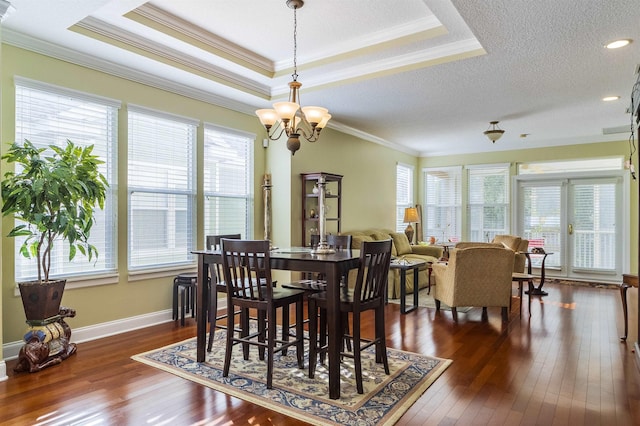 dining room featuring a notable chandelier, ornamental molding, dark wood-type flooring, and a wealth of natural light