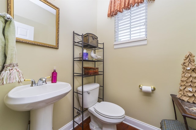 bathroom with wood-type flooring, toilet, and sink