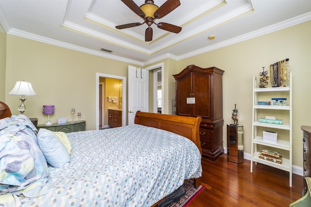 bedroom with ensuite bath, ceiling fan, a raised ceiling, dark hardwood / wood-style flooring, and ornamental molding