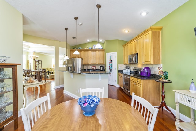 dining space featuring a notable chandelier, dark hardwood / wood-style floors, and vaulted ceiling