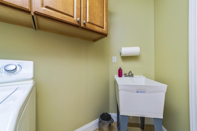 laundry area featuring sink, cabinets, and washer / dryer