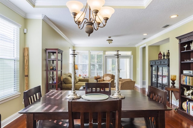 dining area featuring dark hardwood / wood-style flooring, a healthy amount of sunlight, and ornamental molding