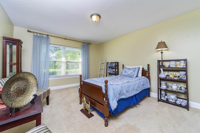 bedroom featuring light colored carpet and a textured ceiling