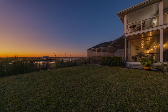 yard at dusk featuring a lanai