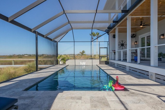 view of swimming pool with pool water feature, glass enclosure, ceiling fan, and a patio area