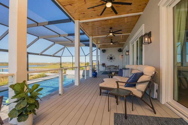 wooden deck with glass enclosure, a water view, and an outdoor hangout area