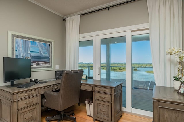 office area with light hardwood / wood-style floors, a water view, and ornamental molding