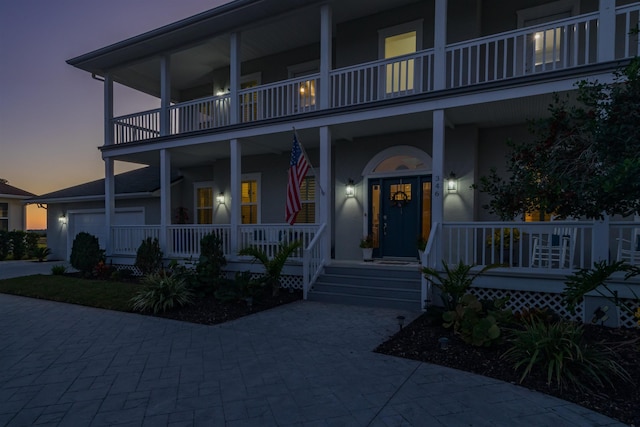 view of front of property with a balcony, a porch, and a garage