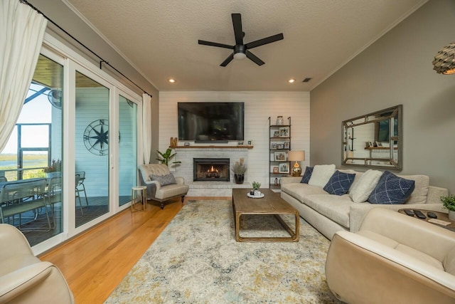 living room with hardwood / wood-style floors, a textured ceiling, ceiling fan, and ornamental molding