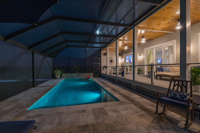 view of pool with glass enclosure, ceiling fan, and a patio area