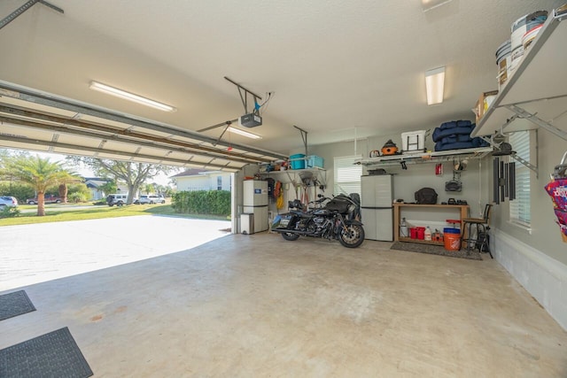 garage featuring a garage door opener and fridge