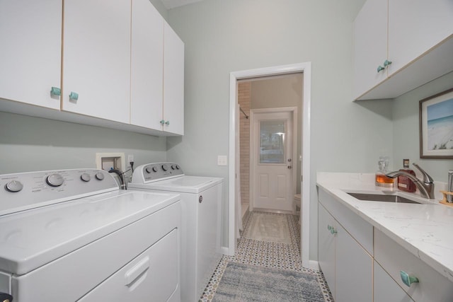 clothes washing area featuring cabinets, light tile patterned floors, washer and dryer, and sink