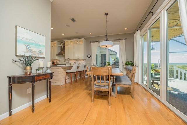 dining space featuring light wood-type flooring and sink