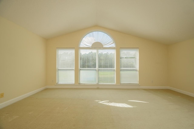 carpeted empty room with vaulted ceiling