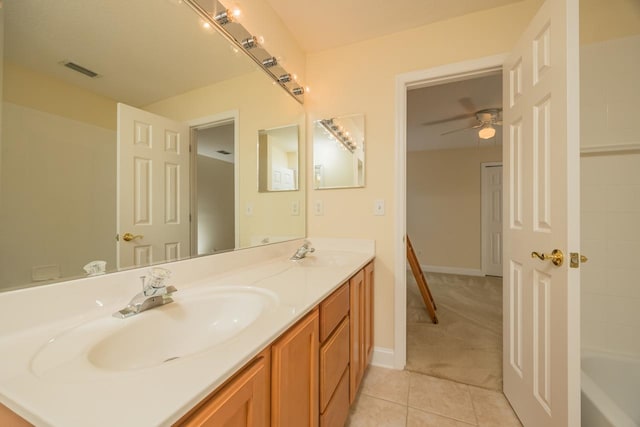 bathroom with tile patterned flooring, ceiling fan, a tub, and vanity