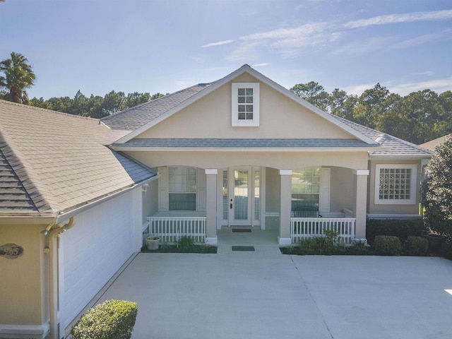 view of front facade featuring a garage, a front lawn, and covered porch