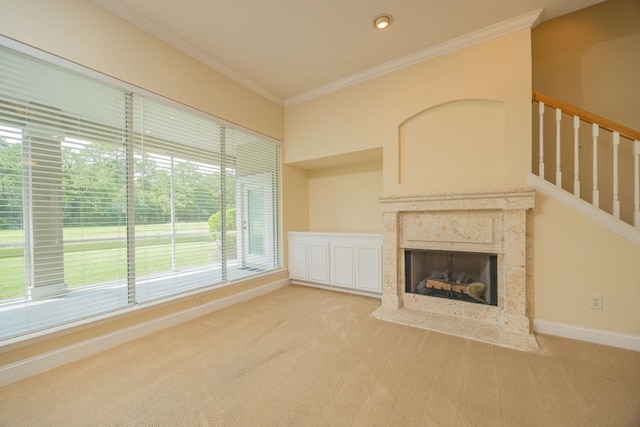 unfurnished living room featuring light carpet, ornamental molding, and a high end fireplace