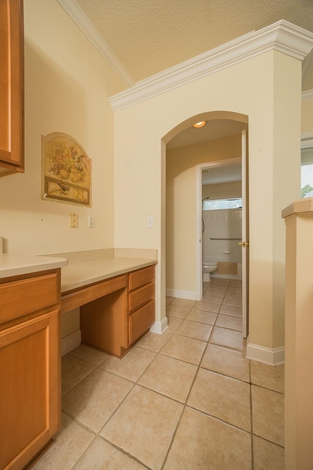 bathroom featuring tile patterned flooring, toilet, crown molding, and a textured ceiling