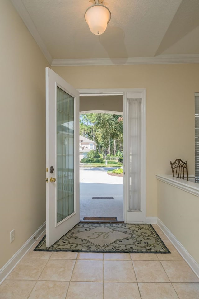 entryway with light tile patterned flooring and ornamental molding