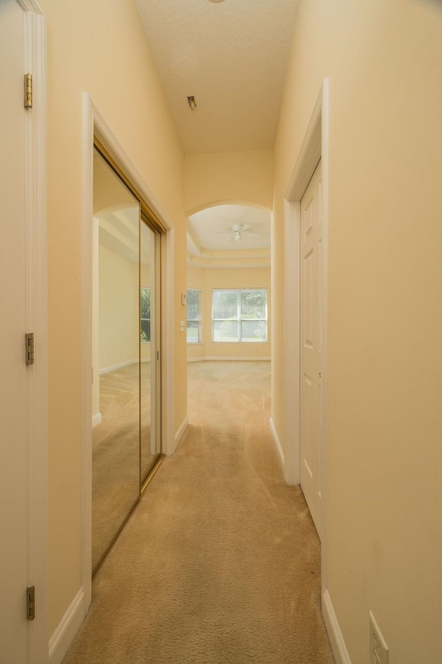 hall with light colored carpet