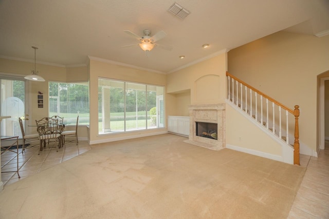 carpeted living room with a high end fireplace, ceiling fan, and ornamental molding