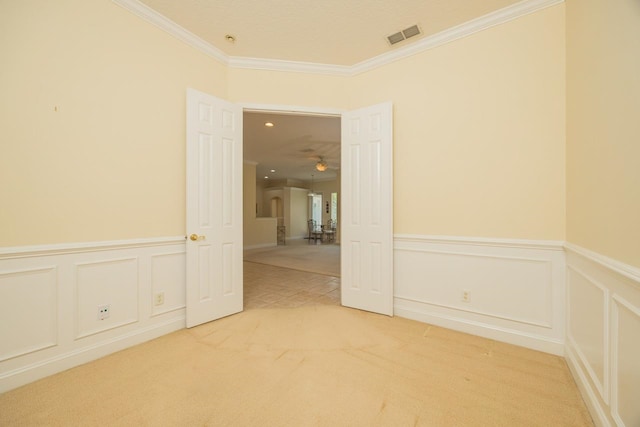 unfurnished room with ceiling fan, carpet, and ornamental molding