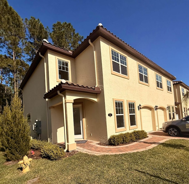 272 Grand Ravine Dr, Saint Augustine, FL 32086 - mediterranean / spanish house with a tile roof, stucco siding, a garage, and a front lawn