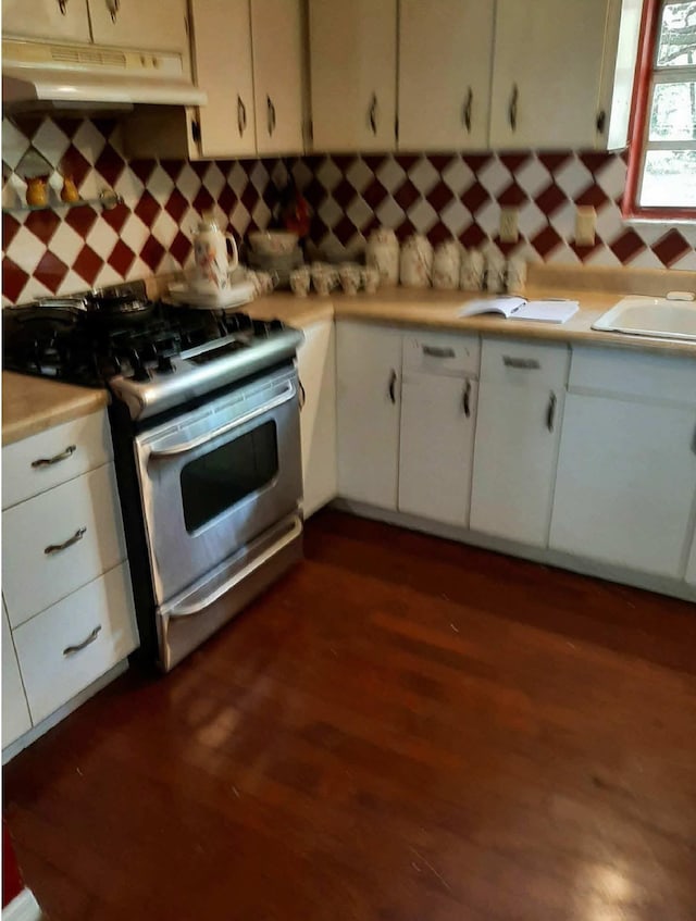 16325 SE 134th Ct, Weirsdale, FL 32195 - kitchen featuring stainless steel gas range oven, under cabinet range hood, light countertops, dark wood-style flooring, and white cabinets