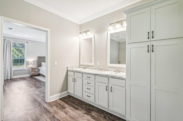 bathroom featuring vanity, hardwood / wood-style flooring, and crown molding