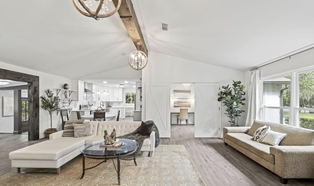 living room featuring hardwood / wood-style flooring, a chandelier, and lofted ceiling with beams