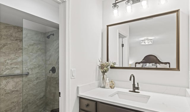 bathroom with tiled shower and vanity