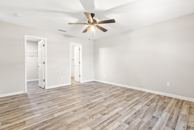 empty room with ceiling fan and light hardwood / wood-style flooring