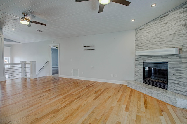 unfurnished living room with ceiling fan, a fireplace, light hardwood / wood-style flooring, and an AC wall unit