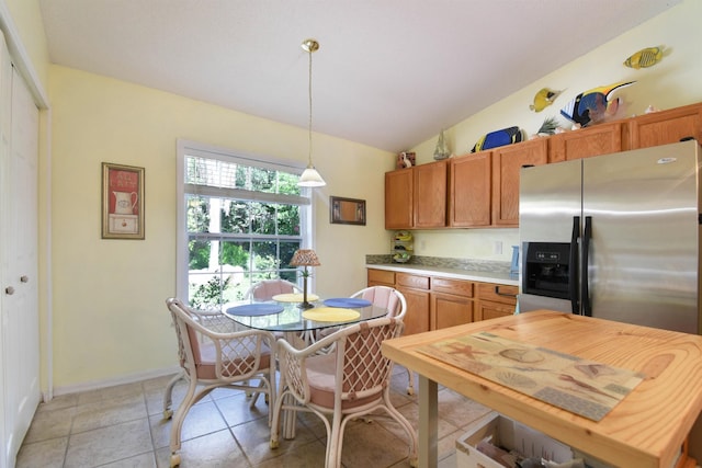 1711 Old Beach Rd, Saint Augustine, FL 32080 - kitchen with stainless steel fridge with ice dispenser, lofted ceiling, light countertops, hanging light fixtures, and brown cabinetry