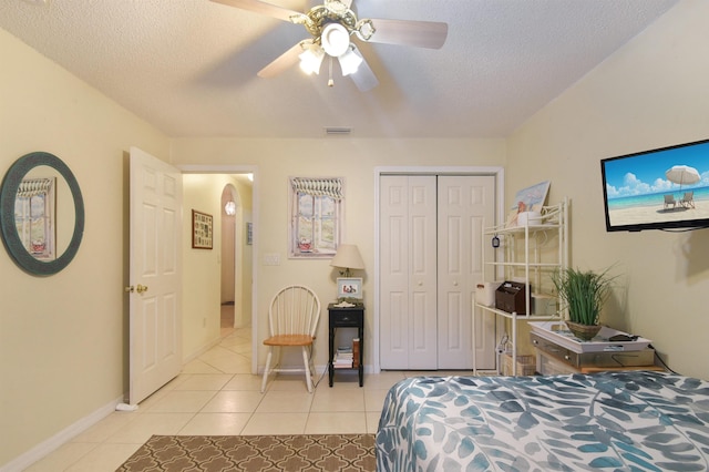 1711 Old Beach Rd, Saint Augustine, FL 32080 - bedroom featuring light tile patterned flooring, a closet, a textured ceiling, a ceiling fan, and arched walkways