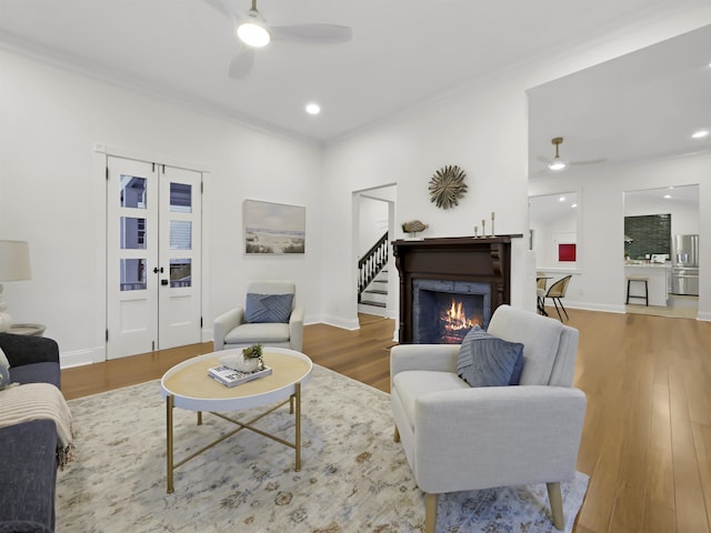 living area with ceiling fan, baseboards, and wood finished floors