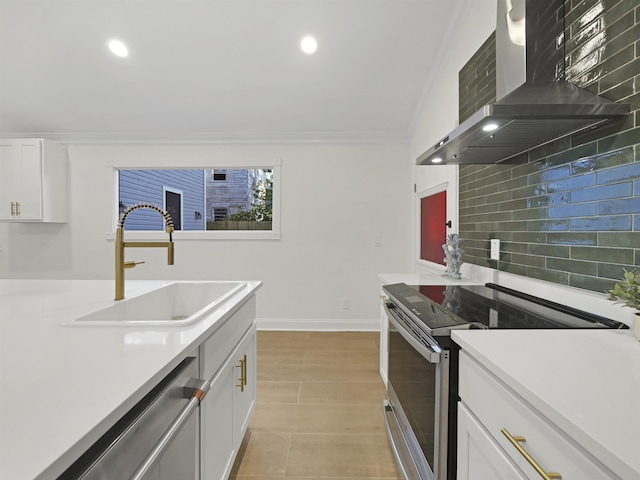 kitchen with a sink, appliances with stainless steel finishes, decorative backsplash, wall chimney exhaust hood, and crown molding