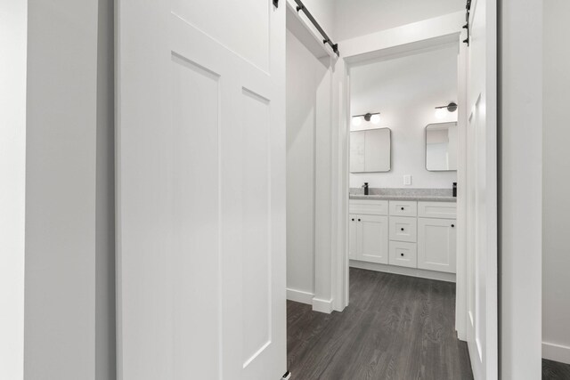 bathroom with wood finished floors, double vanity, and baseboards