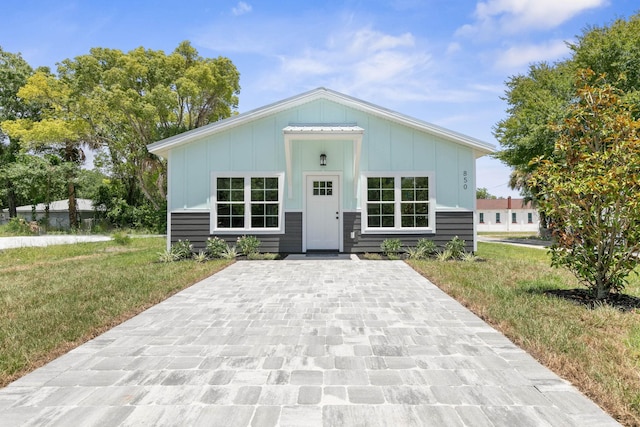 view of front of home with board and batten siding and a front lawn
