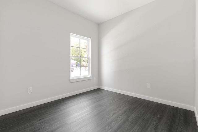 empty room featuring dark wood finished floors and baseboards